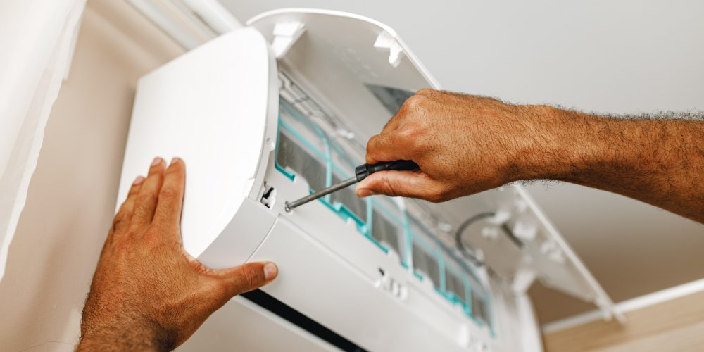close-up-of-repairman-fixing-air-conditioner-in-a-RX2G5X8 (2) close-up-of-repairman-fixing-air-conditioner-in-a-RX2G5X8 (2)